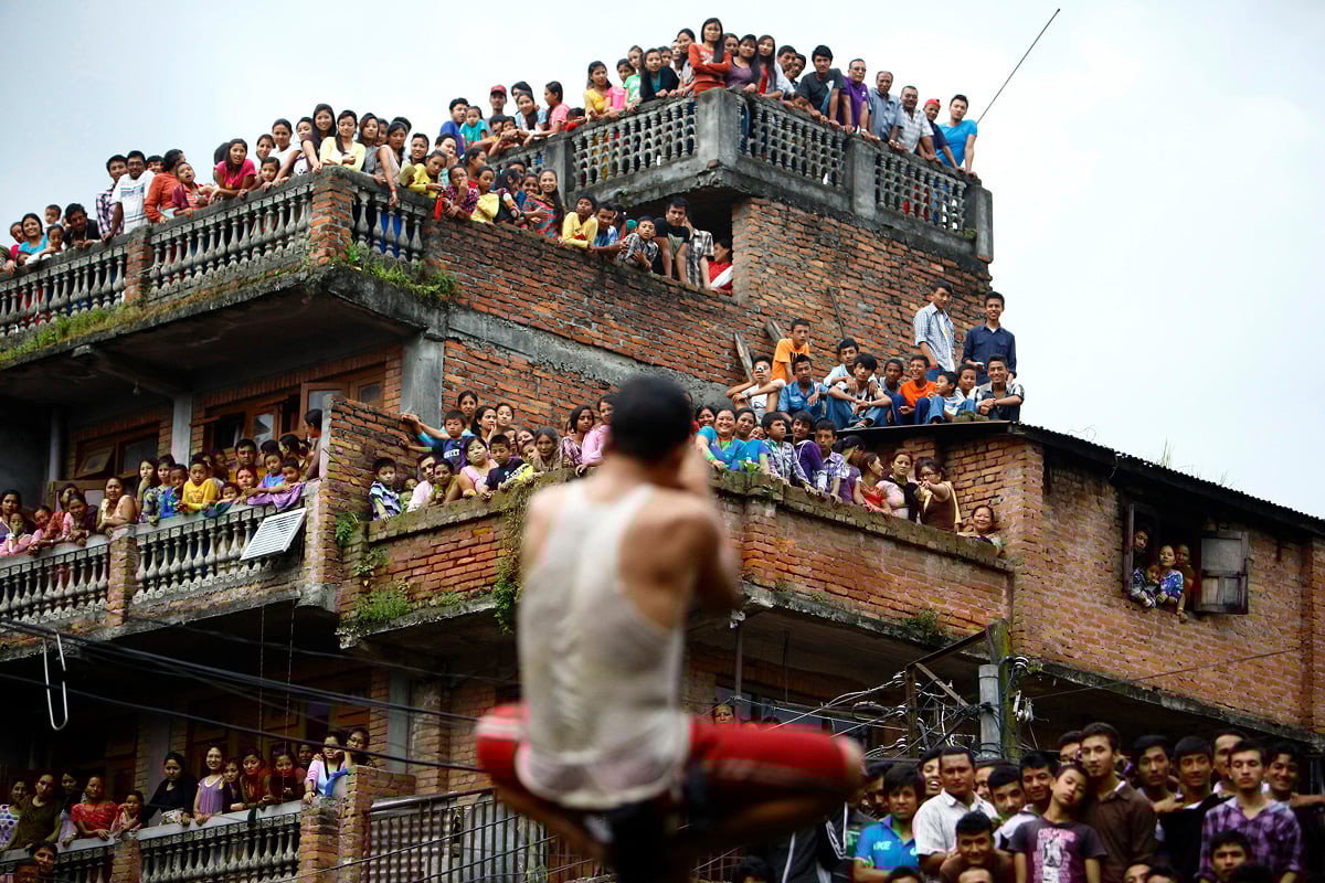 People observe the Deopokhari festival from the roof of a house in Khokana August 23, 2013. During the annual festival, a live goat is thrown into a pond and the team of devotees that retrieves the animal first wins. REUTERS/Navesh Chitrakar