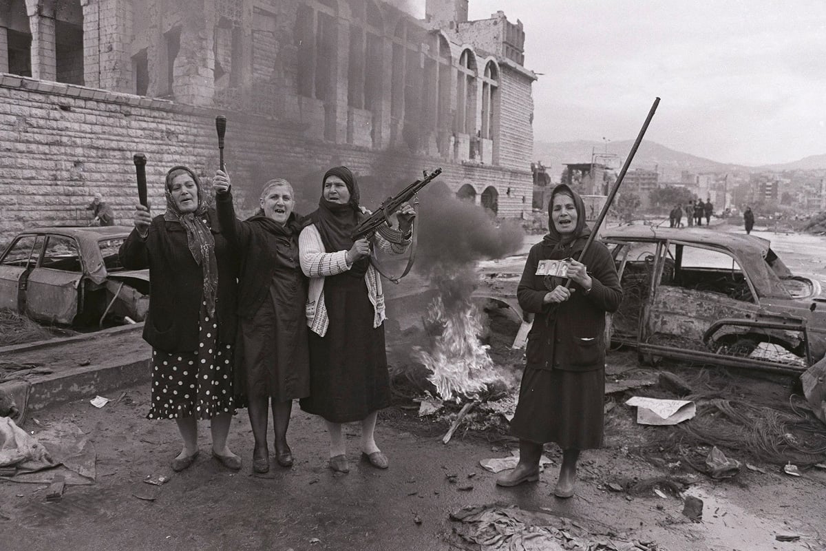 Relatives of kidnapping victims armed with a Kalashnikov rifle and clubs block the Galerie Semaan crossing between East and West Beirut in Lebanon. 