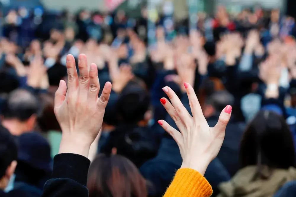 Two people raise their hands in the air