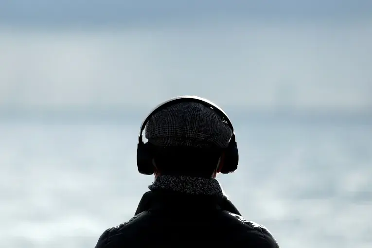 Audio, A man looking away with headphones on
