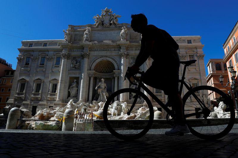 A cyclist passes the Trevi Fountain, as Italy begins to ease some of the restrictions of the coronavirus disease (COVID-19) lockdown, in Rome, Italy May 7, 2020. REUTERS/Guglielmo Mangiapane