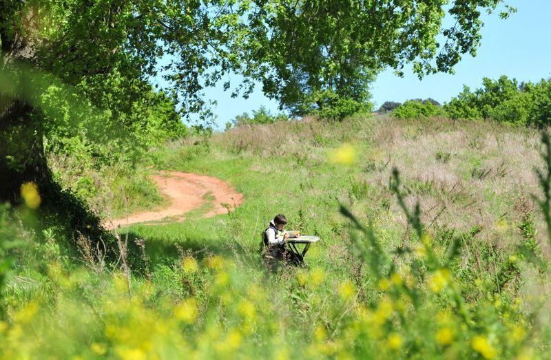 Giulio Giovannini, 12, with a tablet, a small camping table and a chair, studies on the top of a hill where he is able to access the Internet to participate in online lessons while schools remain closed due to the spread of the coronavirus disease (COVID-19), in Scansano, Italy, April 15, 2020. REUTERS/Jennifer Lorenzini -