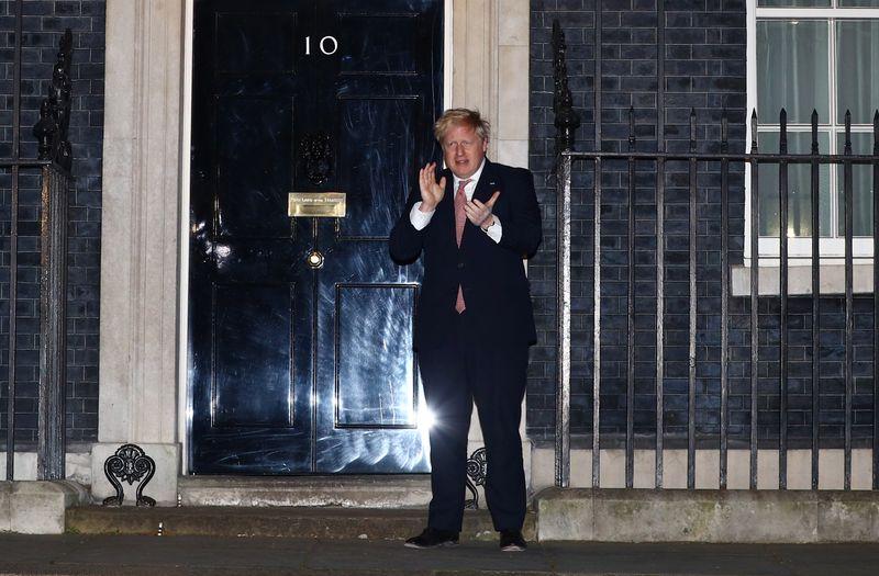 Britain's Prime Minister Boris Johnson applauds outside 10 Downing Street during the Clap for our Carers campaign in support of the NHS, as the spread of the coronavirus disease (COVID-19) continues, London, Britain, March 26, 2020. REUTERS/Hannah McKay
