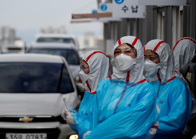 FILE PHOTO: Medical staff in protective gear work at a 'drive-thru' testing center for the novel coronavirus disease of COVID-19 in Yeungnam University Medical Center in Daegu, South Korea, March 3, 2020. REUTERS/Kim Kyung-Hoon
