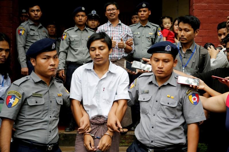 FILE PHOTO: Detained Reuters journalist Kyaw Soe Oo and Wa Lone are escorted by police as they leave after a court hearing in Yangon, Myanmar, Aug. 20, 2018. REUTERS/Ann Wang/File Photo