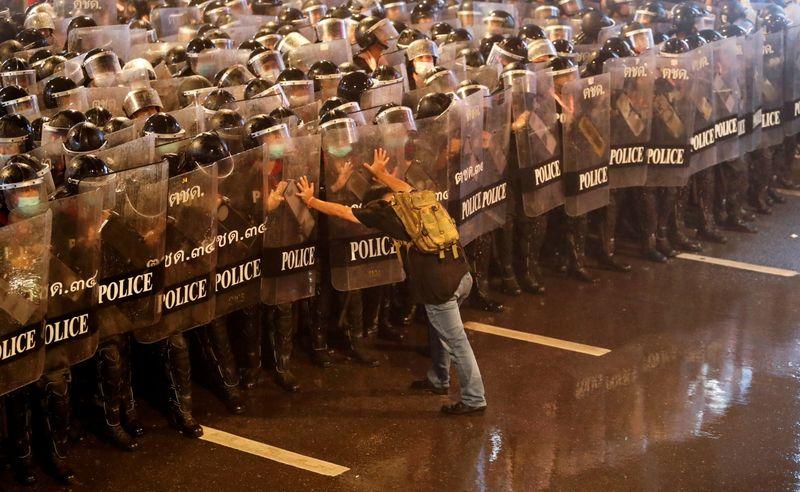 Anurak Jeantawanich, 52, pushes against police officers during an anti-government protest in Bangkok, Thailand, October 16, 2020. 