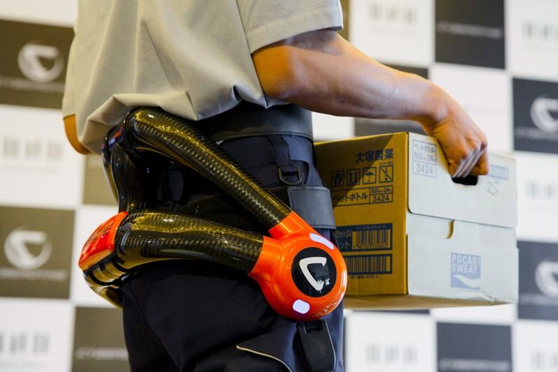 A man wears a Cyberdyne Robot Suit HAL robotic back support during a presentation at Haneda airport in Tokyo July 2, 2015. The suit, which the company says supports the lower back when lifting heavy loads, is to be introduced to staff at Tokyo's Haneda Airport, the airport operator Japan Airport Terminal (JAT) and Cyberdyne said in a statement. REUTERS/Thomas Peter - GF10000146331