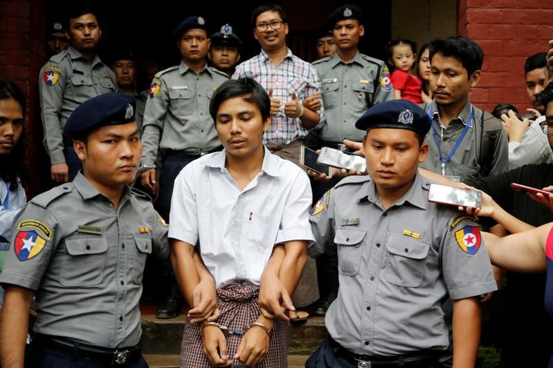 Detained Reuters journalist Kyaw Soe Oo and Wa Lone are escorted by police as they leave after a court hearing in Yangon, Myanmar, August 20, 2018. REUTERS/Ann Wang