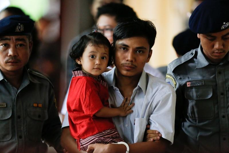 Detained Reuters journalist Kyaw Soe Oo carries his daughter Moe Thin Wai Zin while escorted by police during a court hearing in Yangon, Myanmar, June 5, 2018. REUTERS/Ann Wang