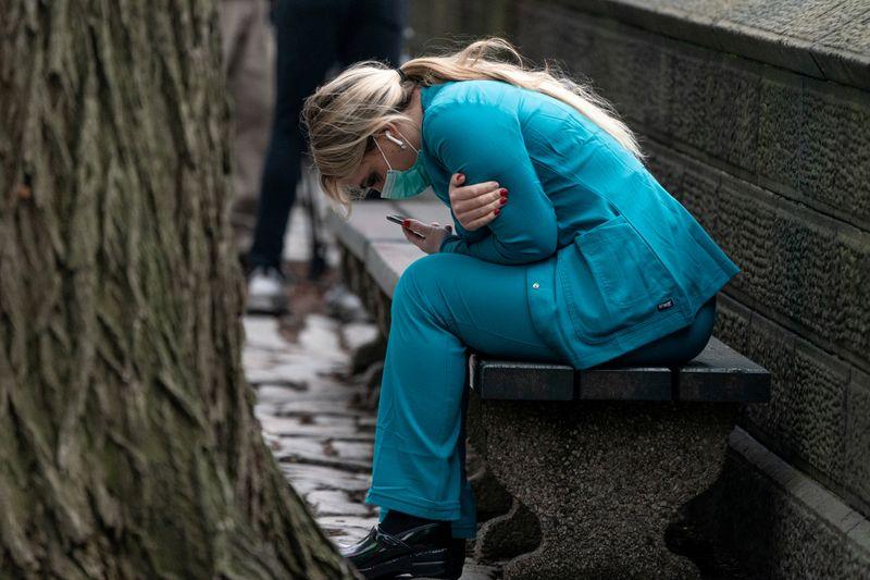 A healthcare worker sits on a bench near Central Park in the Manhattan borough of New York City, U.S., March 30, 2020. REUTERS/Jeenah Moon