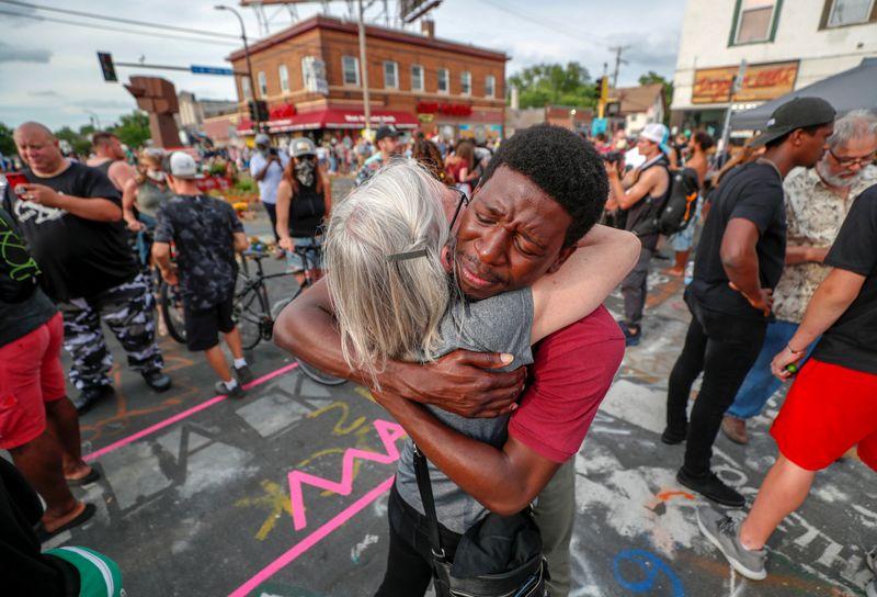 Kathy Boyum (L) is hugged by Jeffrey Edwards during a reconciliation revival, part of an event to mark Juneteenth, which commemorates the end of slavery in Texas, two years after the 1863 Emancipation Proclamation freed slaves elsewhere in the United States, amid nationwide protests against racial inequality in Minneapolis, Minnesota, U.S. June 19, 2020. REUTERS/Eric Miller 