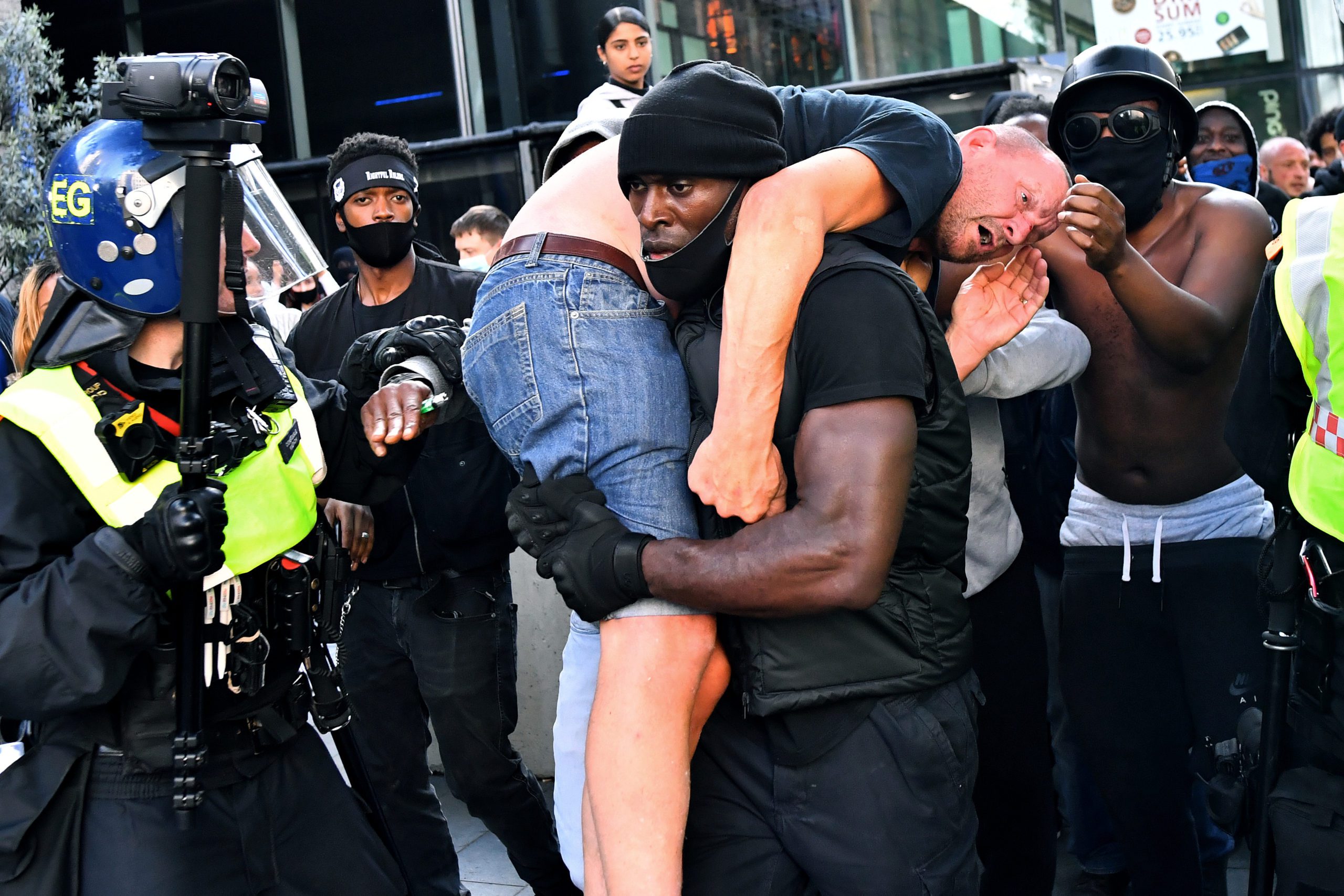 Patrick Hutchinson, a protester, carries a suspected far-right counter-protester who was injured, to safety, near Waterloo station during a Black Lives Matter protest following the death of George Floyd in Minneapolis police custody, in London, Britain, June 13, 2020. REUTERS/Dylan Martinez   