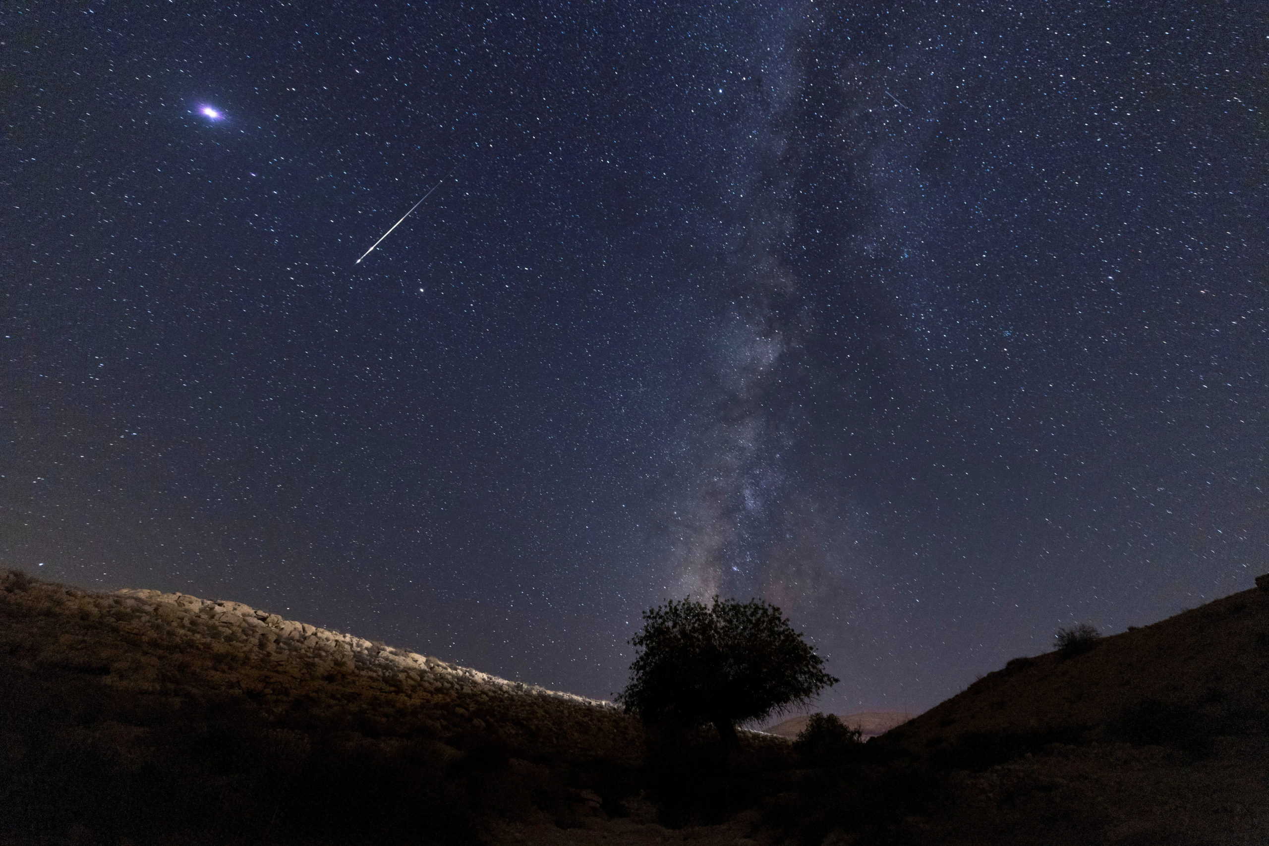 A meteor streaks past stars in the night sky during the annual Perseid