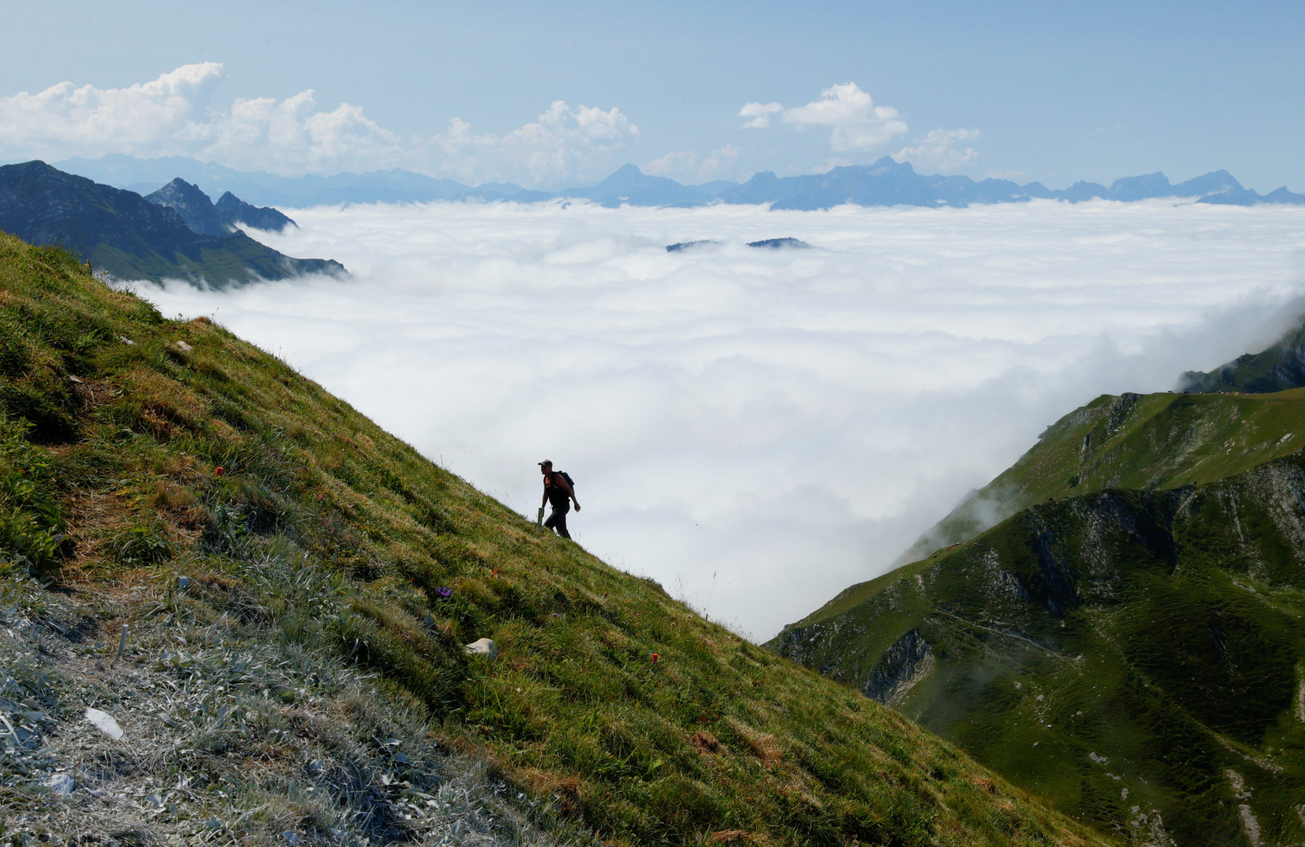 A hiker walks up to the Moleson summit during a cloud inversion in Gruyeres