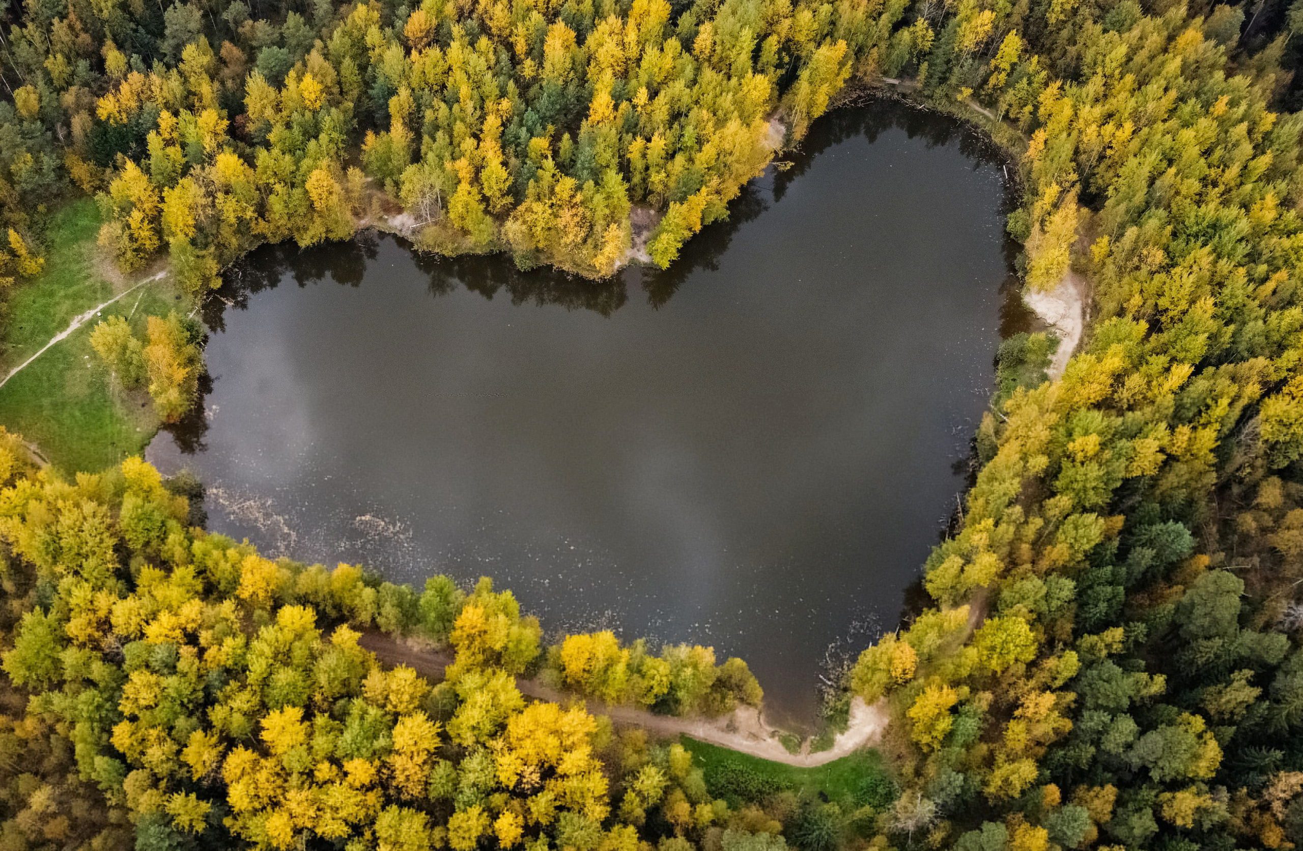 A lake in a shape of a heart is seen surrounded by autumn-coloured trees outside Balashikha