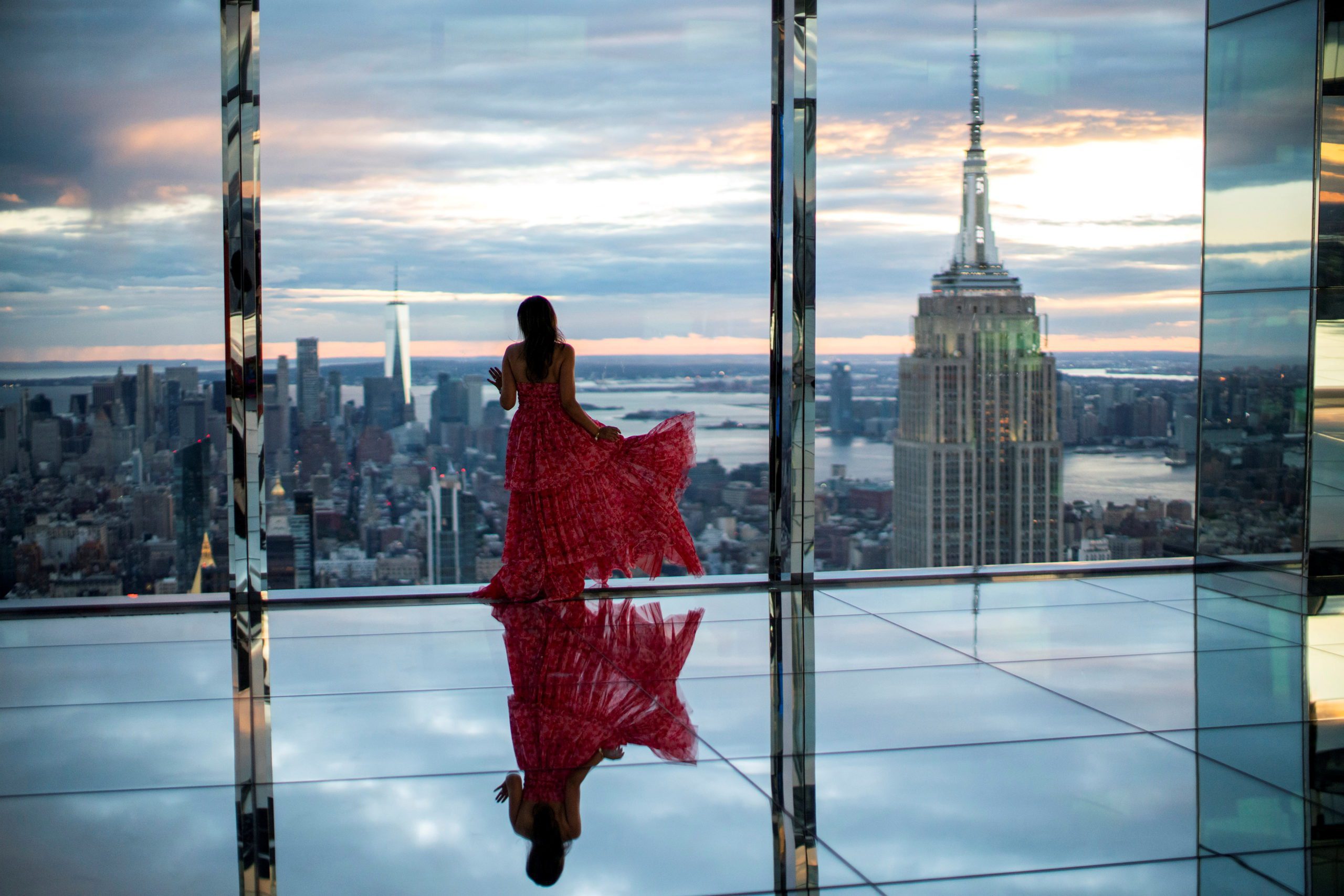 A woman looks at The Empire State Building and the New York Skyline