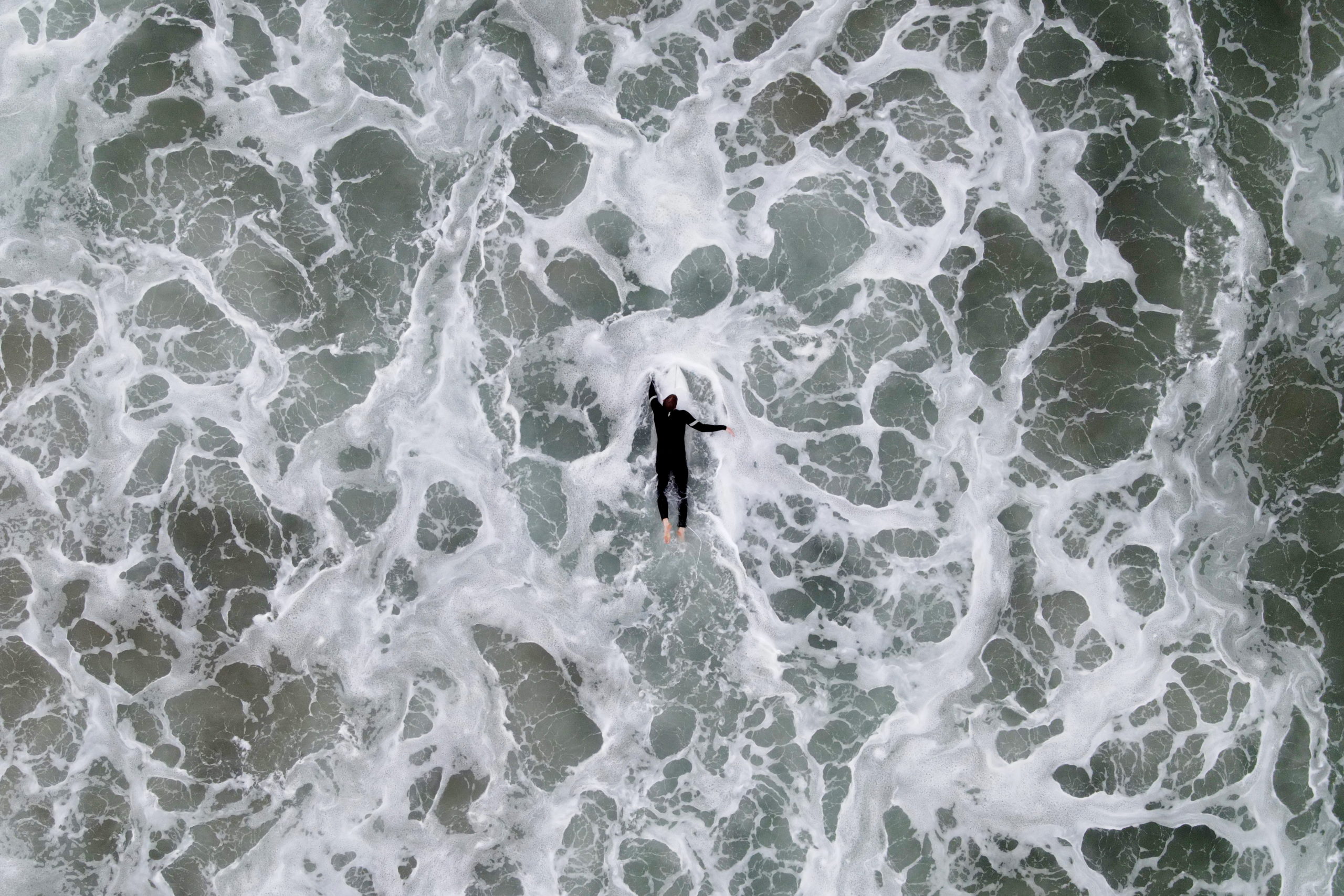 Surfers take to the waves about a month after an oil spill closed Huntington Beach