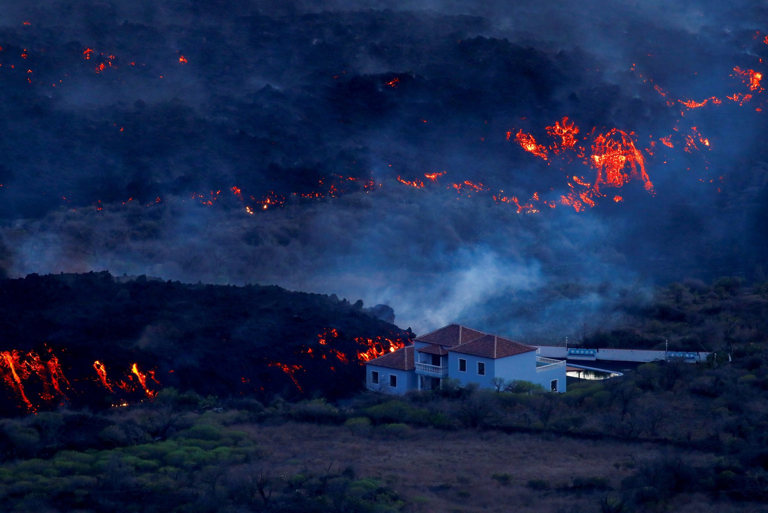 A house is photographed in Tajuya next to the lava of the Cumbre Vieja volcano that continues to erupt