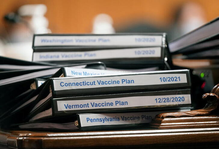 FILE PHOTO: Folders with COVID-19 vaccine plans for various states are stacked on a table as Xavier Becerra, U.S. President Joe Biden's nominee for Secretary of Health and Human Services, testifies during his confirmation hearing before the Senate Health, Education, Labor and Pensions Committee at the U.S. Capitol in Washington, U.S., February 23, 2021. Leigh Vogel/Pool via REUTERS/File Photo