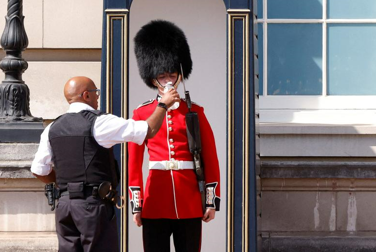 A member of the Queen's Guard receives water to drink during the hot weather, outside Buckingham Palace in London, Britain, July 18. REUTERS/John Sibley