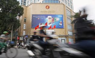 Traffic moves past a Vincom trading center in Hanoi March 29, 2012. Vincom Joint Stock Co, Vietnam's leading real estate developer, has raised $185 million via five-year dollar bonds and plans to list them on the Singapore stock exchange, it said in a statement late on Wednesday. REUTERS/Kham (VIETNAM - Tags: BUSINESS REAL ESTATE)