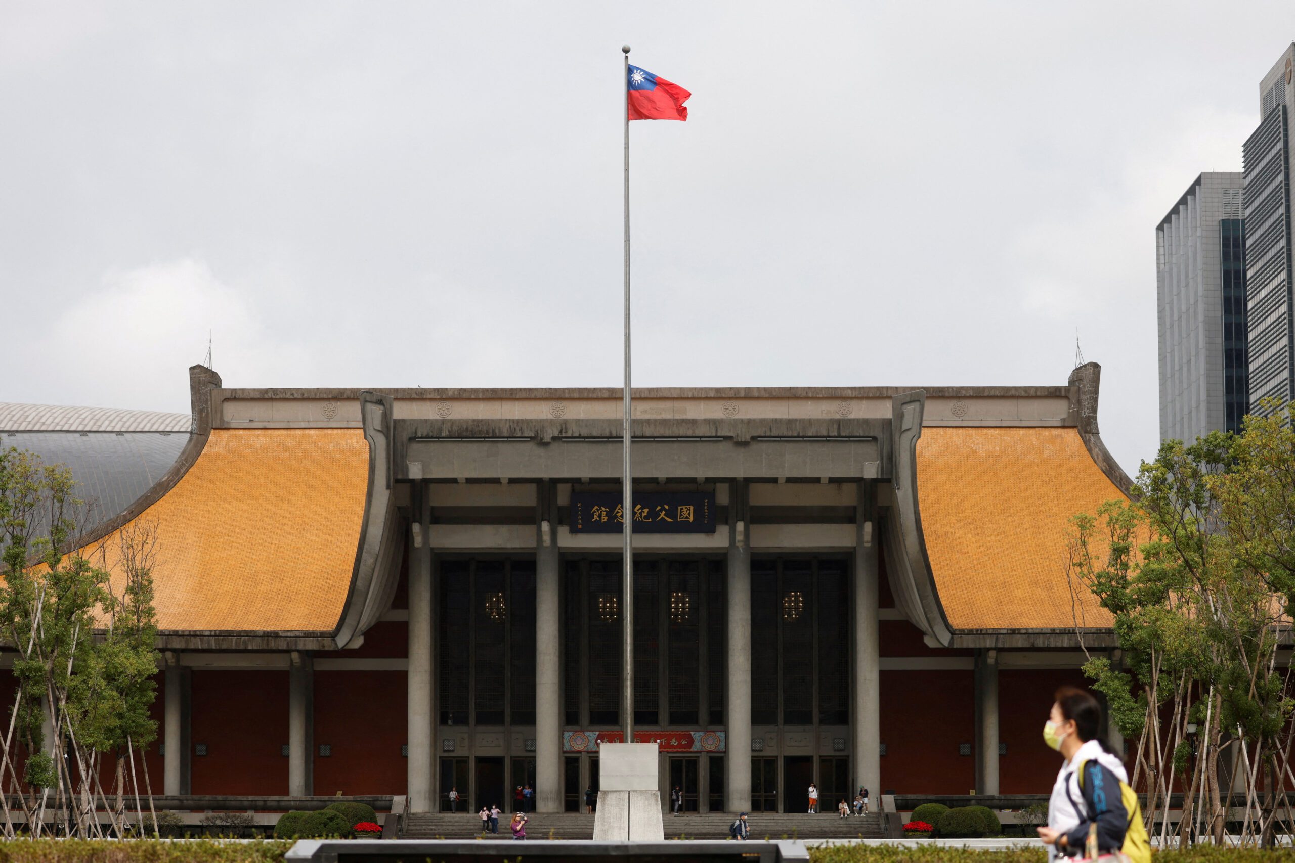 FILE PHOTO: People walk near a fluttering Taiwanese flag outside the Sun Yat-Sen Memorial Hall in Taipei, Taiwan November 16, 2023. REUTERS/Carlos Garcia Rawlins/File Photo