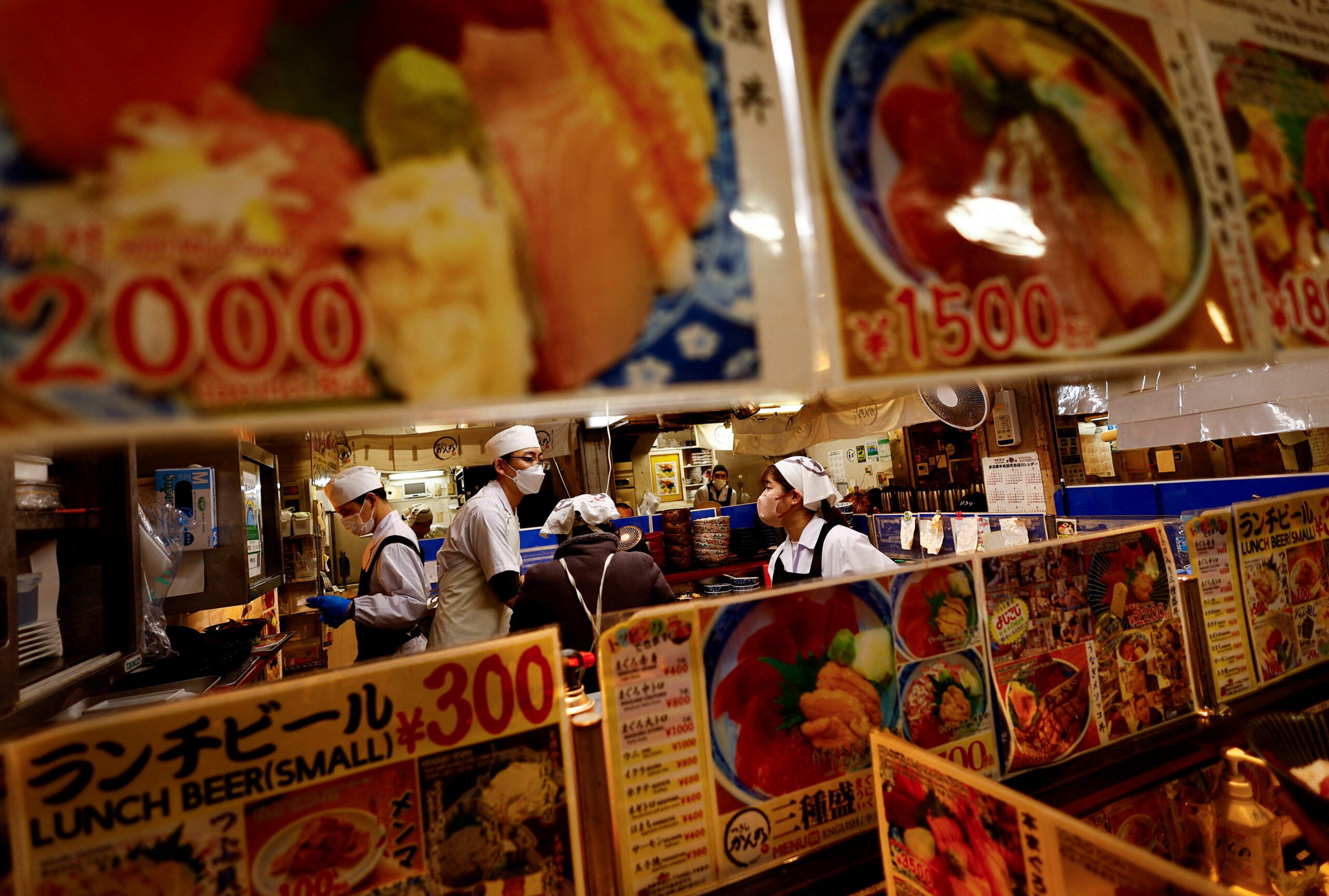 FILE PHOTO: Employees of a seafood restaurant work in their kitchen space at Tsukiji Outer Market in Tokyo, Japan, Feb. 15, 2024.  REUTERS/Issei Kato/File Photo