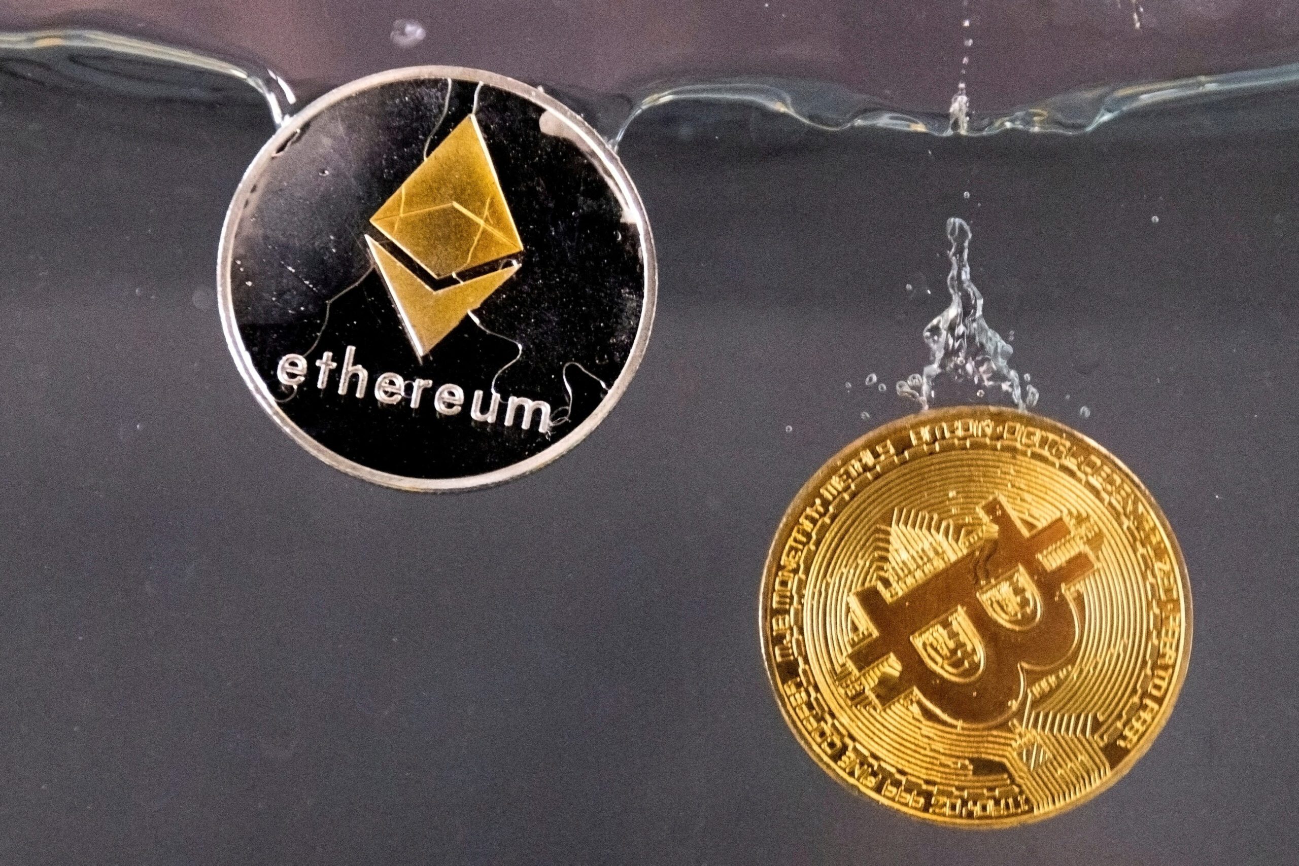 FILE PHOTO: Tokens representing cryptocurrencies bitcoin and ether plunge into water in this illustration taken May 17, 2022. REUTERS/Dado Ruvic//File Photo