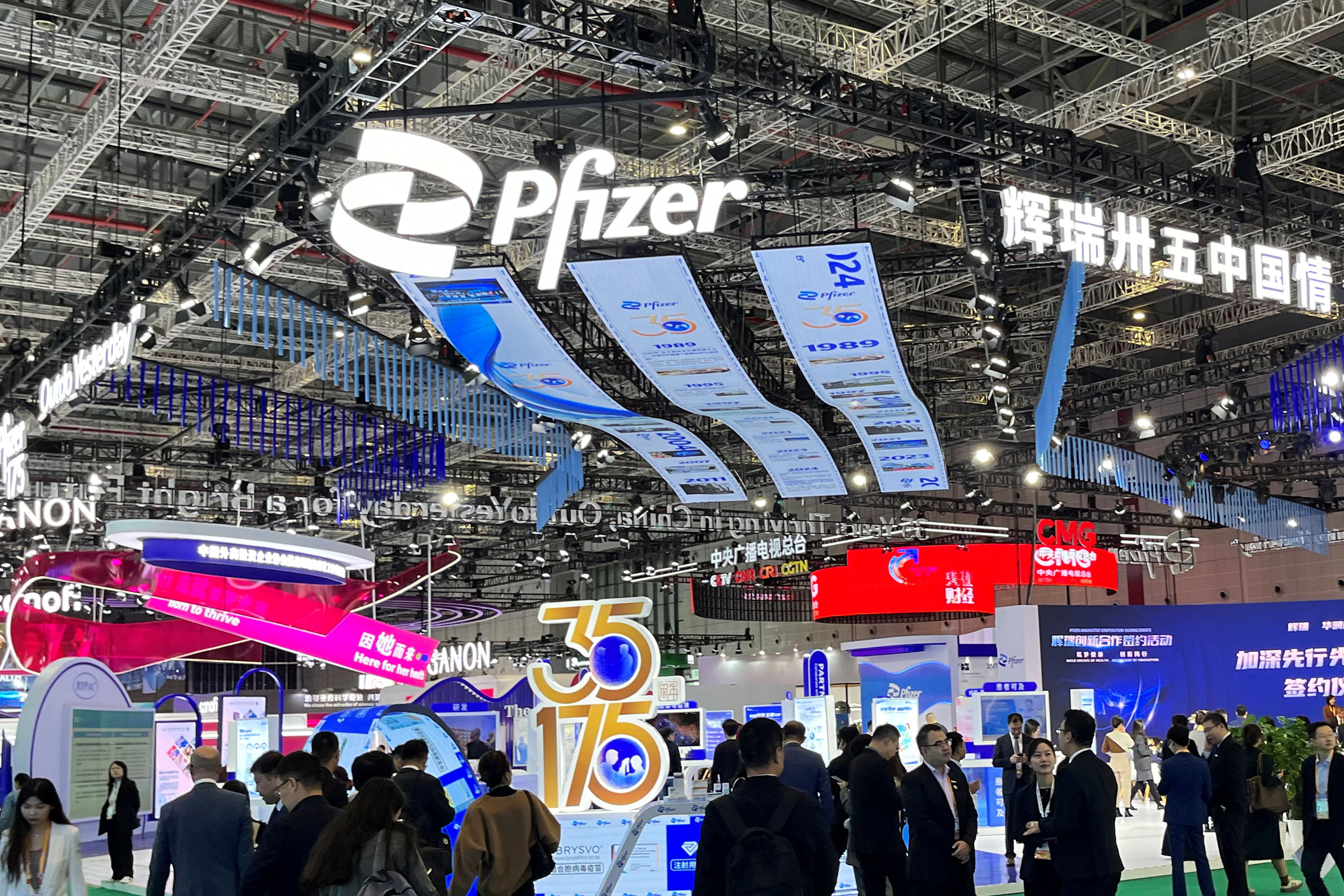 People walk past the booth of drugmaker Pfizer booth at the China International Import Expo (CIIE) in Shanghai, China November 7, 2024. REUTERS/Andrew Silver/File Photo